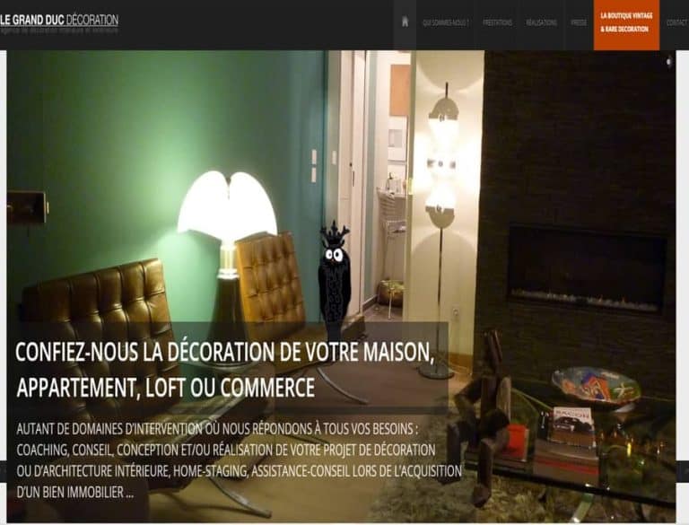 Salon avec mur vert, cheminée et mobilier en cuir.