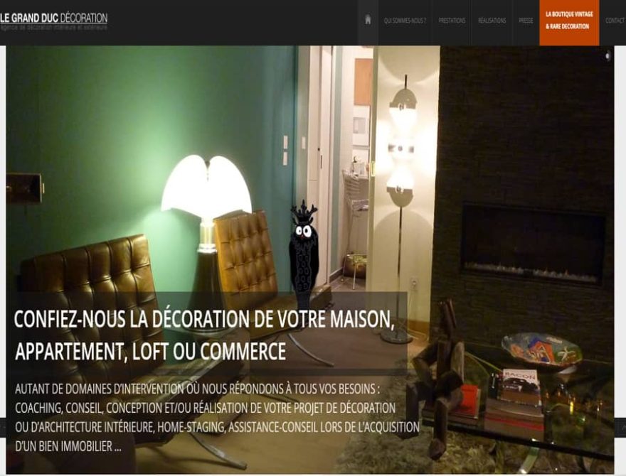Salon avec mur vert, cheminée et mobilier en cuir.