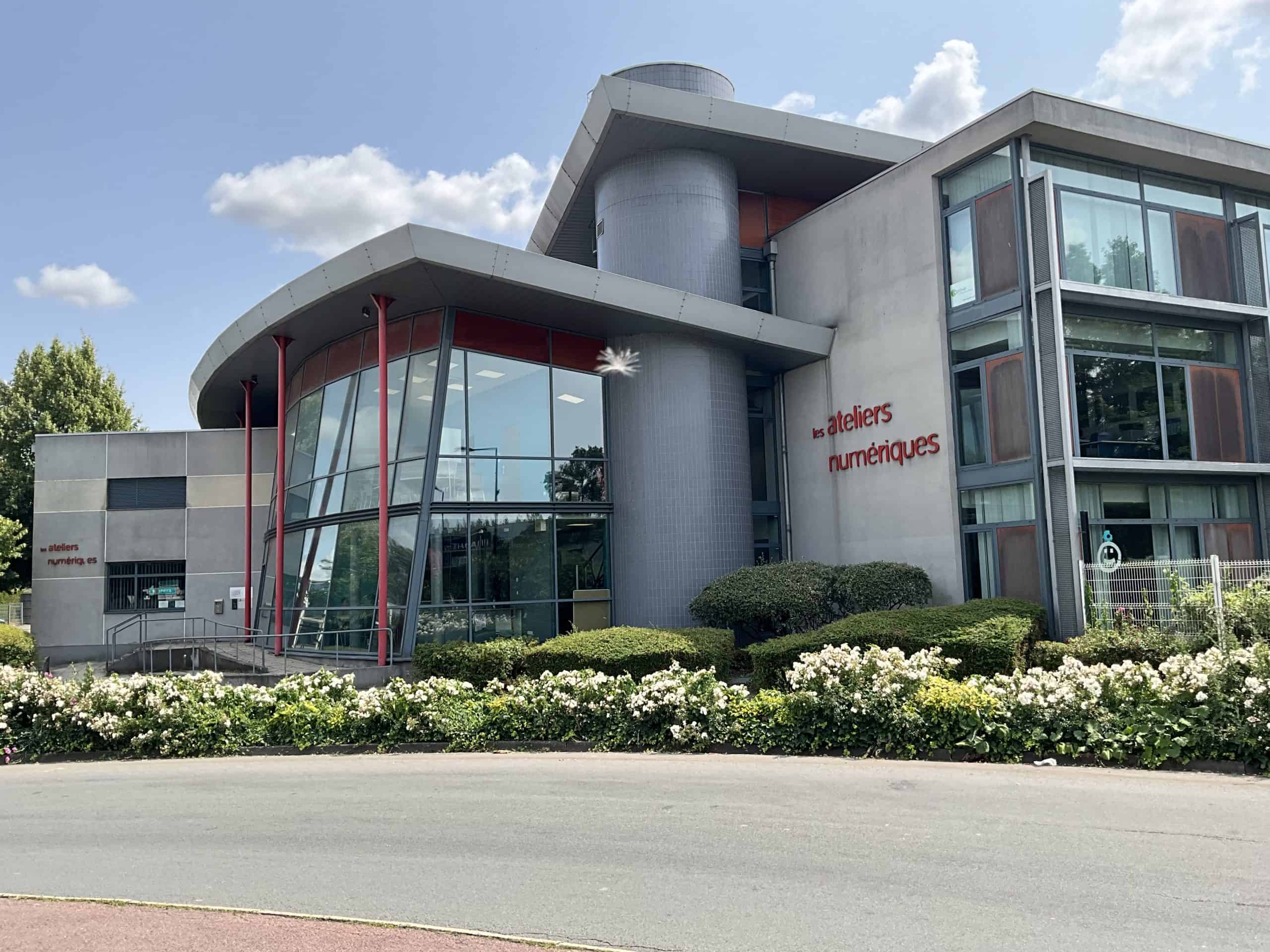 Atelier numérique ARC EN SOFT, bâtiment contemporain avec grandes fenêtres et espace extérieur fleur.