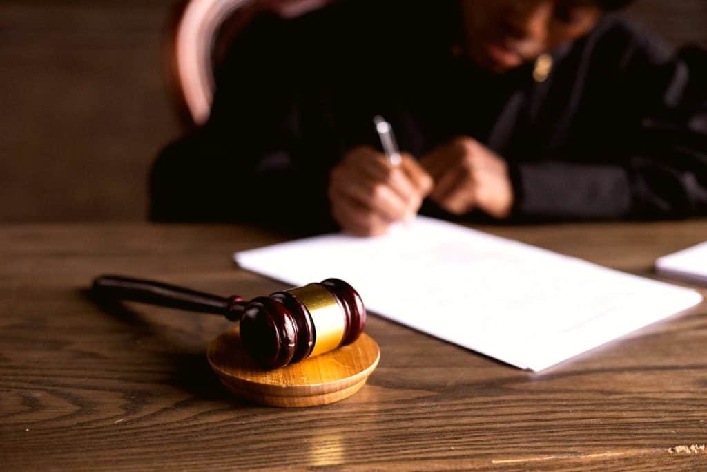 Juge signant une décision avec un marteau de justice : décision du Conseil d’État sur les cookies